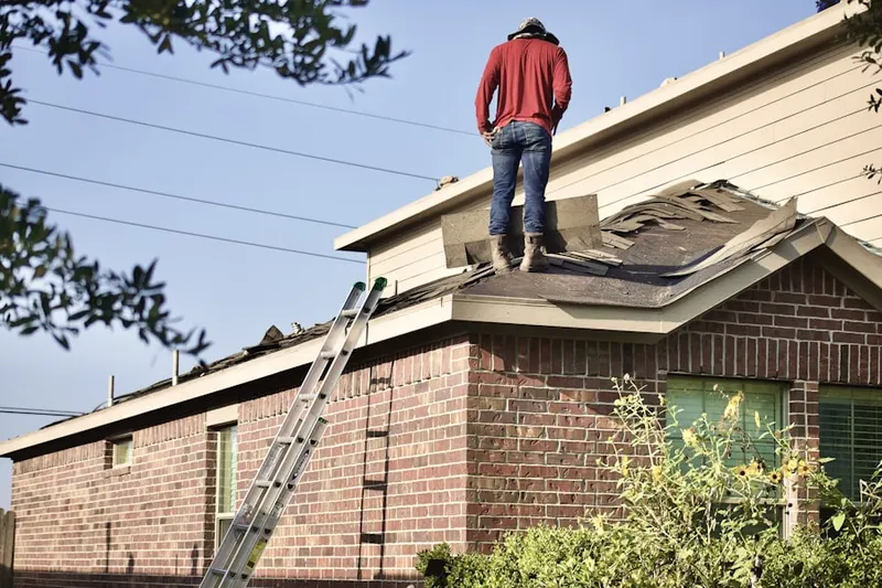 Professional roofer working on a residential roof in Alto